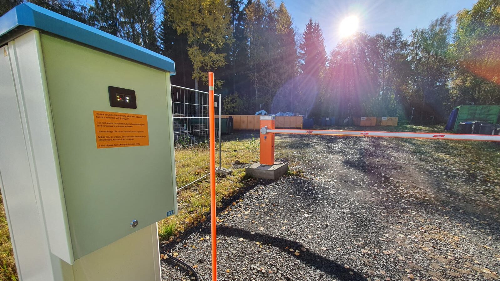 Hartaanselänrannan Asuntomessualueen jäteasema, kuvassa lukulaite, puomi ja takana näkyy jätelavoja.